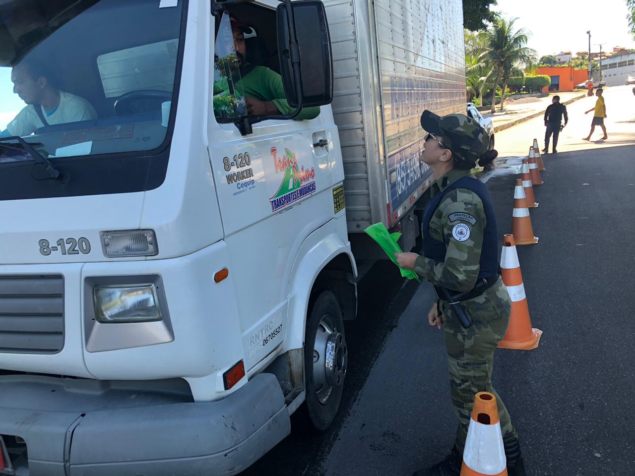 mulher entrega panfleto a um motorista